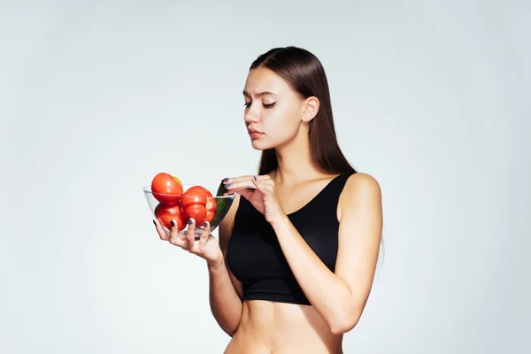 La ragazza si siede su una dieta e tiene un piatto con verdure e frutta in mani — Foto Stock