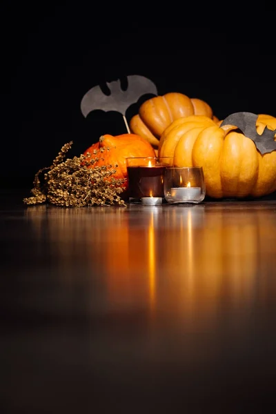 Para o cenário da casa para o Halloween, mentir abóboras amarelas e laranja, velas acesas e desenhos de morcegos — Fotografia de Stock