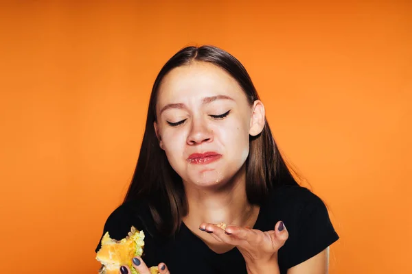 Een jong meisje gezocht om gewicht te verliezen, maar aten een schadelijke vette hamburger — Stockfoto