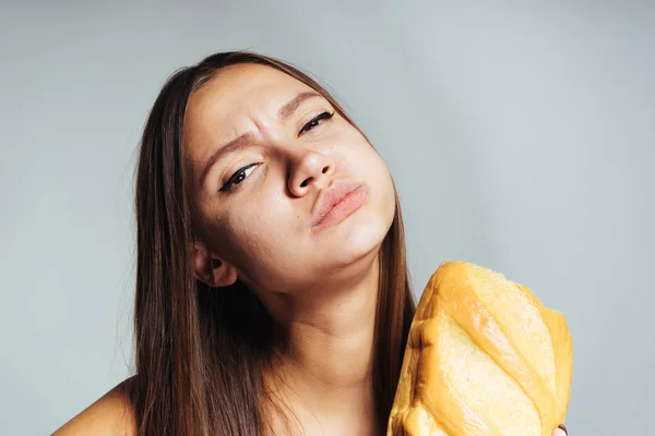 Aç kız hevesle zararlı beyaz ekmek yiyor — Stok fotoğraf