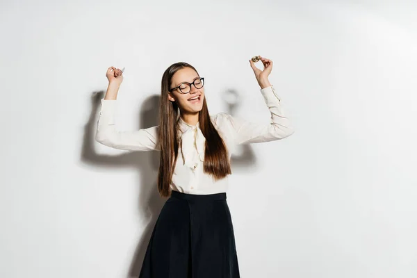 Alegre chica en una blusa blanca y con gafas levantó monedas de oro en sus manos, aislado, bitcoins, criptomoneda — Foto de Stock