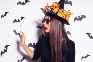 Geniş Cadılar Bayramı partisi sanat tasarımında Halloween cadı bir siyah korkunç şapka gülümsüyor. Yarasalar birkaç arka planı.