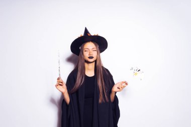 Sihirli değnek ile Halloween cadı. Güzel genç kadın cadı şapka ve kostüm şaşırttı... Geniş Cadılar Bayramı partisi sanat tasarım