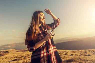 elleri sıcak bir bardağa bir dağın tepesinde olan