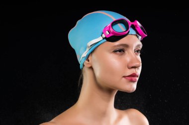 Kız bir yüzme kap ve gözlük siyah bir arka plan üzerinde duruyor