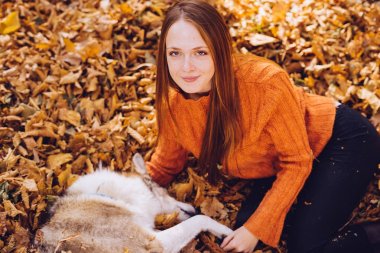 güzel kız sonbahar yaprakları yatıyor ve çalış onun köpek, altın yaprağı, altın sonbahar ile