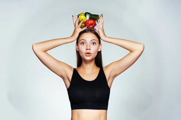 Ragazza tiene una ciotola di verdure sulla testa, sport, yoga, corretta alimentazione, cibo sano — Foto Stock
