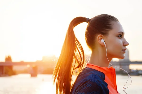 Dívka v sportovní jednotné provádí večer běžet západem slunce pozadí — Stock fotografie