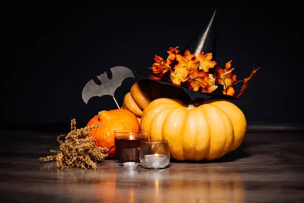 Halloween pompoen hoofd, Herfstbladeren, verschrikkelijke hoed op een zwarte achtergrond, Halloween party — Stockfoto