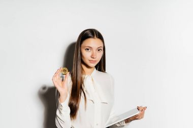 Genç başarılı iş kadını altın bitcoin onun elinde tutan ve Veri Kripto para birimi üzerinde çalışmalar