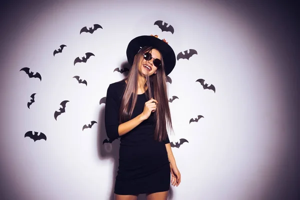 Sexy gothic meisje gekleed in een heks voor halloween, houdt een toverstaf, lacht — Stockfoto