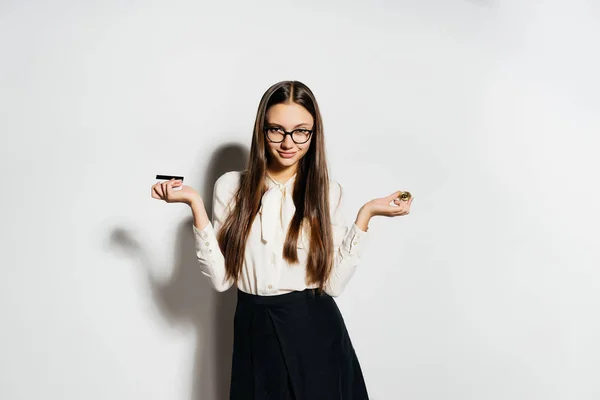 Joven exitosa mujer de negocios en gafas tiene un bitcoin de oro y una tarjeta bancaria en las manos — Foto de Stock