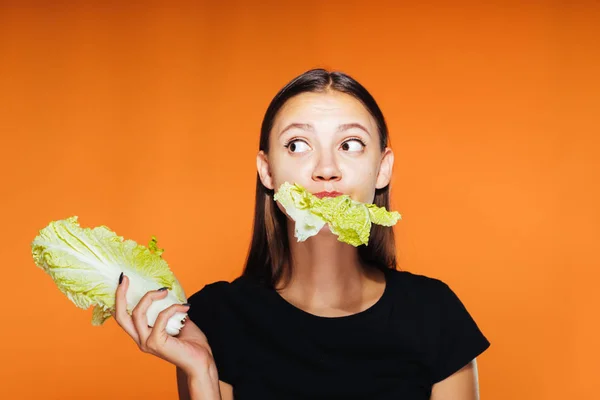 Genç bir kız kilo vermek istiyor, yararlı Pekin lahana tutar ve yiyor — Stok fotoğraf