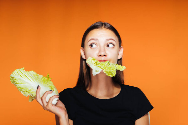 a young girl wants to lose weight, holds useful Peking cabbage and eats it