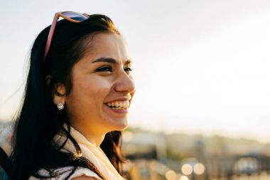 Gün batımında şehirde yürüyüş bir sırt çantası ile kız Gezgin