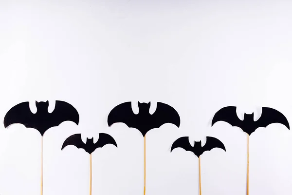 Sobre fondo blanco, murciélagos negros pintados sobre palos de madera —  Fotos de Stock