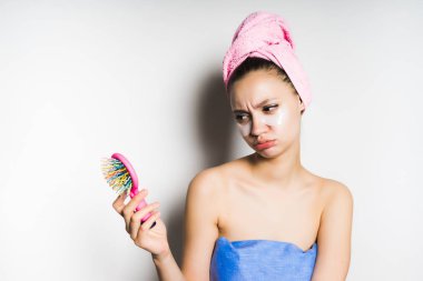 Kafasındaki bir havlu ile kız tarak onun kollarında görünüyor.