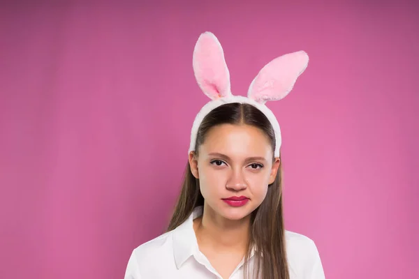 Una ragazza in orecchi di coniglio rosa guarda irritatedly avanti — Foto Stock