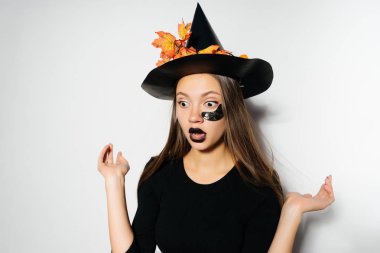 genç seksi gizemli kız giyinmiş bir cadı, Cadılar Bayramı kutluyor, korkmuş gibi görünüyor