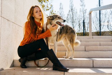 güzel genç Kızıl saçlı kız büyük köpeğini merdivenlerde oturan ile parkta yürüyüş