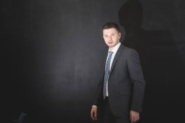 siyah bir arka plan üzerinde poz iş elbiseli genç adam
