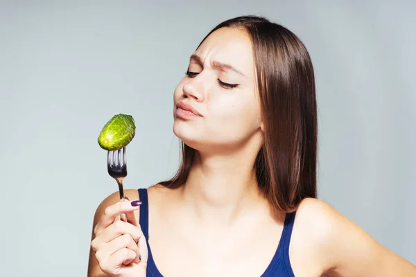 Fiatal gyönyörű lány azt akarja, hogy lefogy, hogy enni alacsony kalóriatartalmú hasznos uborka — Stock Fotó