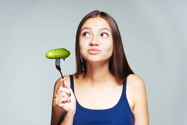 Fiatal gyönyörű lány azt akarja, hogy lefogy, hogy enni alacsony kalóriatartalmú hasznos uborka — Stock Fotó