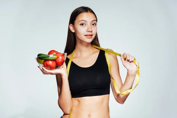 Jovem menina bonita quer perder peso, mantém um prato com vegetais úteis e frutas nas mãos — Fotografia de Stock