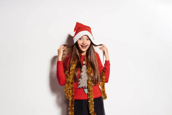 Jovem menina feliz celebra Ano Novo e Natal, em camisola engraçada vermelha e boné — Fotografia de Stock