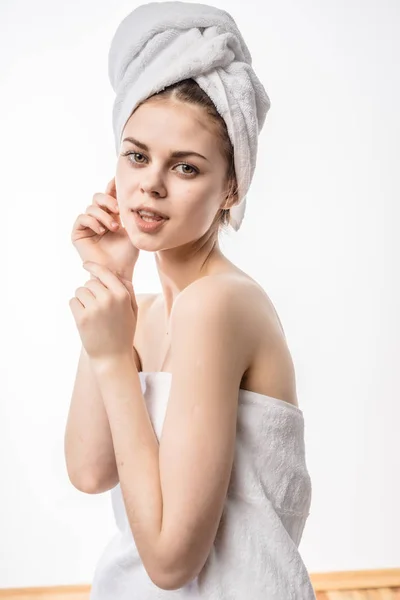 Flicka med en handduk på huvudet känns ansiktet — Stockfoto