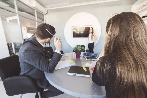 Ragazza in un abito da lavoro mostra ai suoi colleghi una presentazione — Foto Stock