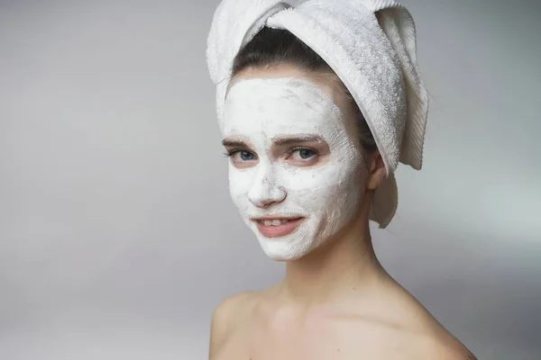 Женщина наслаждается белым спа-маком, вытирает лицо. Чистая кожа — стоковое фото