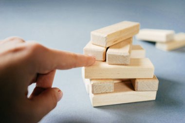 Kız bir parmak ahşap bloklar küçük bir yığın puan.