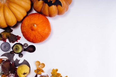 Cadılar Bayramı için beyaz bir tablo üzerinde bir ev dekorasyon için kompozisyon yalan sarı ve turuncu kabak, Yanan Mum kokulu, Sarı yapraklar ve tahta kaşıklar