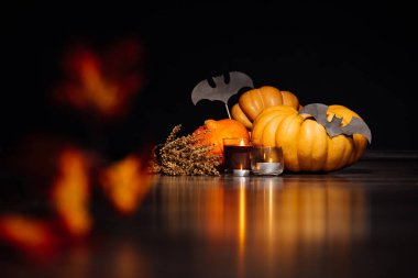 Cadılar Bayramı'nda ev dekorasyon için kompozisyon yalan kokulu mumlar yanan sarı ve turuncu kabak