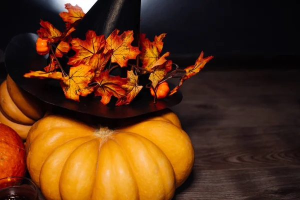 Skladba pro dekoraci domu pro halloween lež žluté a oranžové dýně, velké černé čarodějnice klobouk — Stock fotografie