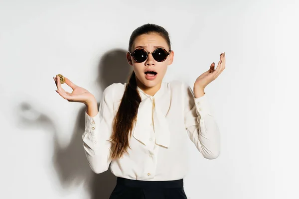 メガネをかけて現代ビジネスの成功若い女性の手で黄金の bitcoin を保持しているし、驚いて見える — ストック写真