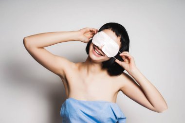 uyumak için bir maske koymak siyah kısa saçlı ve izole gülüyor, güzel kız