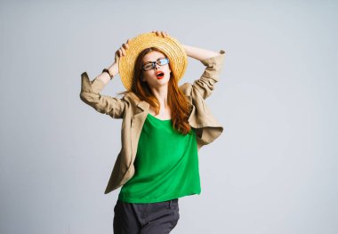 Kızıl saçlı güzel kız bir şapka ve gözlük, ellerini kaldırdı ve biraz kameraya bak ağzını açtı