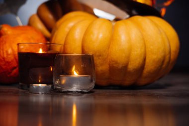 Cadılar Bayramı için bir ev dekorasyon için bir kompozisyon yalan sarı ve turuncu su kabakları, büyük kara cadı şapkası sarı sonbahar ile dekore edilmiş bırakır ve yanan mumlar