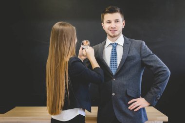 yakışıklı adam ceketli kamera ve gülümsüyor benziyor. Kız adamın yanında duruyor
