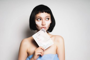 yüzünde bir maske onun elinde tutan ve düşünceli bir kenara arıyor yamalar ile duş sonra kısa siyah saçlı güzel kız