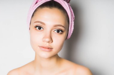 Beyaz bir arka plan üzerinde izole kamera duş başında sevimli pembe bir havlu ile bakar sonra kız