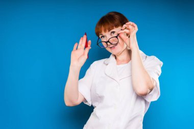 neşeli Kızıl saçlı hemşire gözlüklerini alır ve elini izole, dalgalar