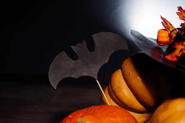 En komposition för att dekorera ett hus för halloween, ligga gula och orange kalebasser, en stor svart häxa hatt dekorerad med gula höstlöv — Stockfoto