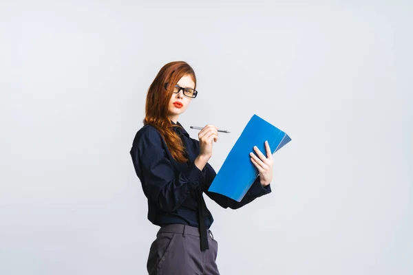 Aufmerksames Mädchen mit Brille wird eine blaue Ordnerbeschriftung aufschreiben, isoliert — Stockfoto