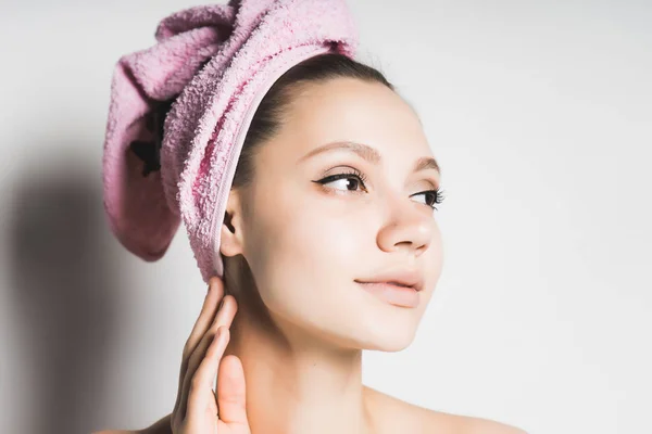 Flicka efter dusch med rosa handduk på hennes huvud söt sida ser, isolerad på vit bakgrund — Stockfoto