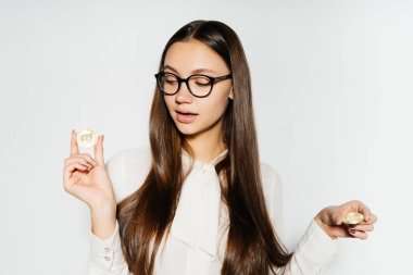 Gözlüklü genç başarılı kendine güvenen kadın altın bitcoin elinde tutar.