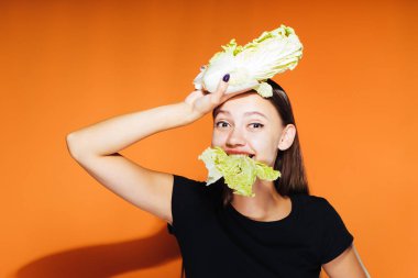 genç güzel kız kilo vermek istiyor, elinde tutar ve yararlı bir Pekin lahana ağız