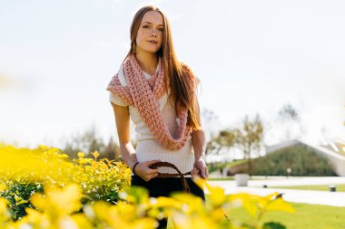 çok hoş bir genç Kızıl saçlı kız köpeğini çok yeşillik ve Güneş çevresinde Park ile yürüyor